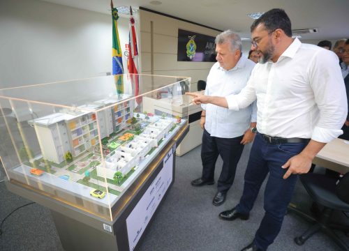 Governador Wilson Lima e o presidente da CEF, Carlos Vieira, observam maquete de conjunto habitacional (Foto: Secom)